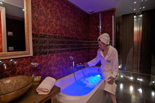 博讷夏兰奇城堡酒店的站在浴室浴缸中的女人