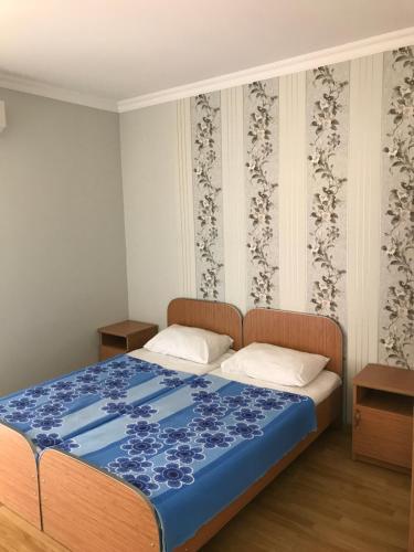 卡瓦拉提Kvariati - Guest House的一间卧室配有一张带蓝色毯子的床