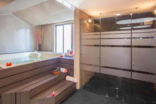 波哥大大使馆公园酒店的带浴缸和玻璃淋浴间的浴室。