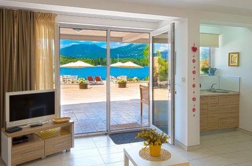 蒂瓦特Aruba Apartments的一间带电视和滑动玻璃门的客厅