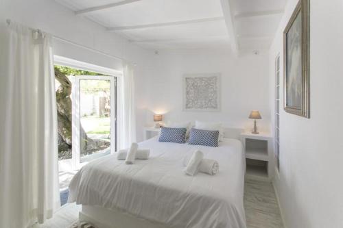 AzoiaO Moinho da Roca的白色的卧室设有白色的床和窗户。