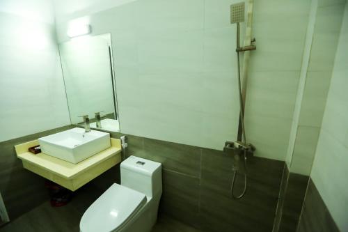 宁平越洪旅馆的一间带水槽、卫生间和镜子的浴室