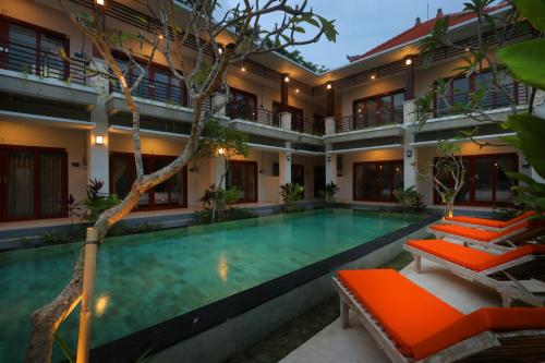 努沙杜瓦阿维萨拉别墅及套房度假村的一座带橙色椅子的房屋前的游泳池