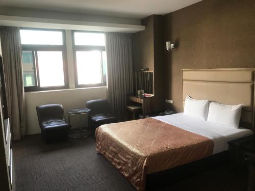 头份市泰莉莎旅店的酒店客房,配有一张床和两把椅子
