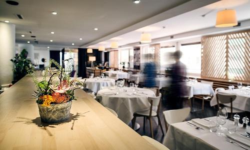 弗里堡阿尔法酒店的餐厅配有带白色桌椅的桌子