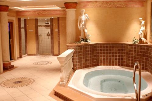 奥博奥多夫Hotel Keindl的一间带按摩浴缸和雕像的浴室