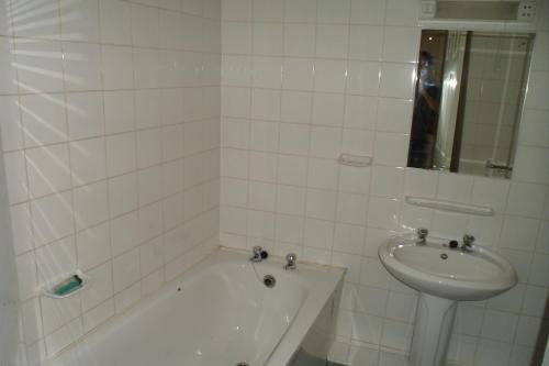 伍斯特塞文河景酒店的白色瓷砖浴室设有浴缸和水槽