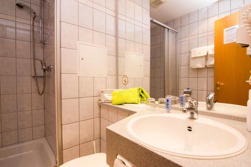武茨巴赫雷恩施泰克公寓式酒店的浴室配有水槽、淋浴和浴缸。