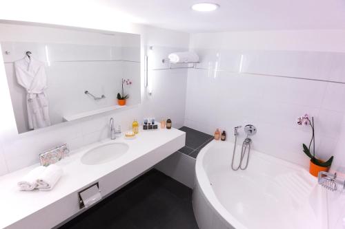内坦亚The Seasons Hotel -Studio & Suite的白色的浴室设有两个盥洗盆和镜子