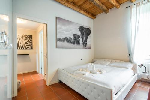科莫Soleluna Apartments - by Relais Di Giada的卧室配有一张床,墙上挂有绘画作品