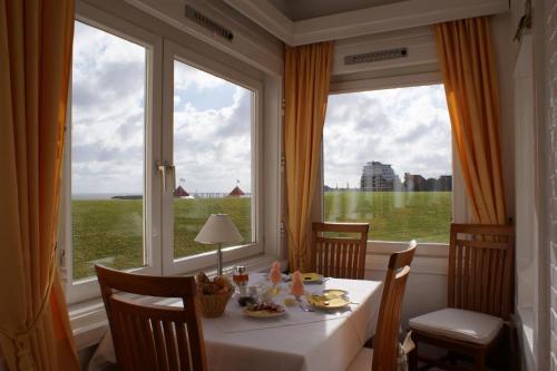 库克斯港贝克罗格酒店的一间带桌子和大窗户的用餐室