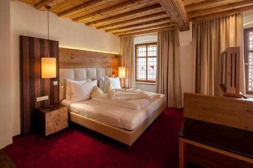 因斯布鲁克最佳西方因斯布鲁克阿德勒戈尔登酒店的一间卧室配有一张床和一台电视