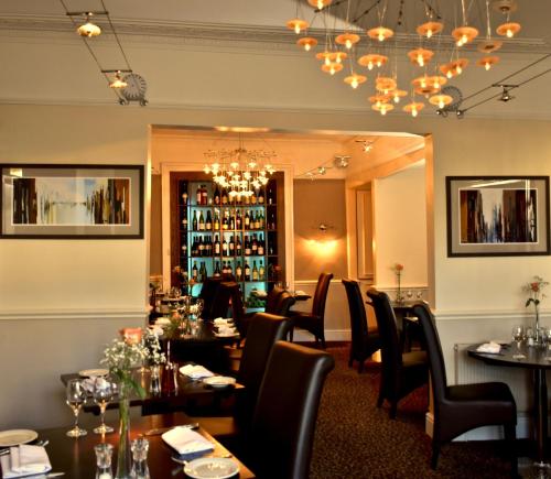 埃克塞特皇庭酒店 的一间带桌椅和吊灯的餐厅