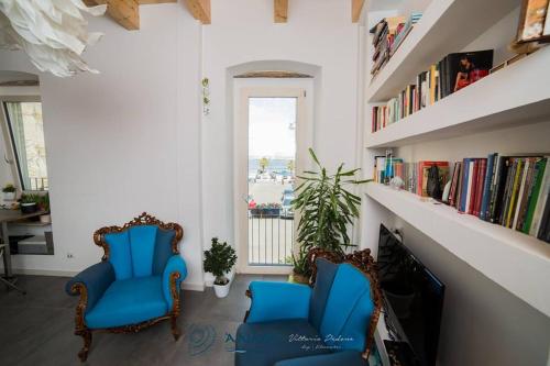 塔兰托Bed & breakfast La Nassa的书架的房间,两把蓝色椅子