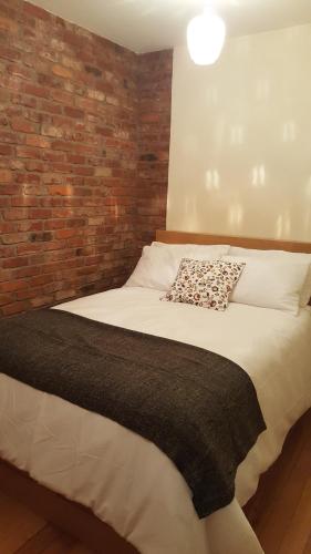 科克Historic Hideaway in Cork City Centre的一间卧室配有一张砖墙床