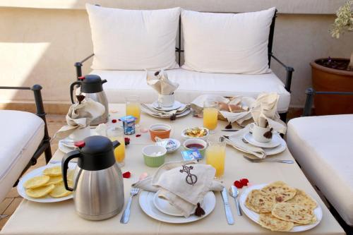 马拉喀什Riad La Croix Berbere De Luxe的床上的早餐桌,包括食物和饮料