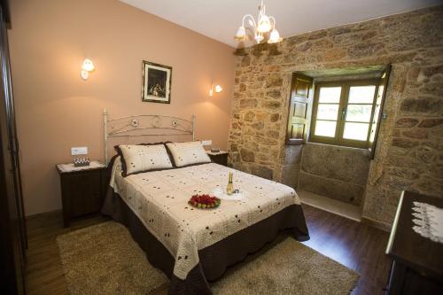 卡马里尼亚斯A Casa da Gandara的一间卧室设有一张床和石墙