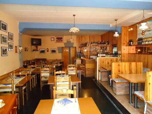 里贝斯的弗里瑟波塔德奴里亚旅馆的配有木桌和椅子的餐厅以及葡萄酒瓶
