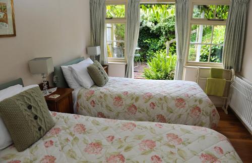 汤顿Town End Farm Cottages的一间卧室设有两张床和两个窗户。