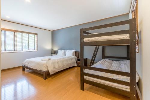 二世古奇迹公寓的一间卧室配有两张双层床和一张床