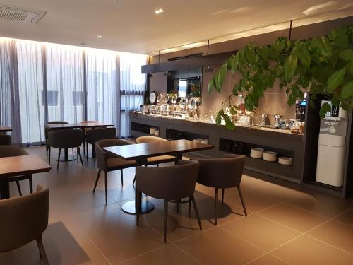 大邱河畔酒店的一间带桌椅的餐厅和一间酒吧