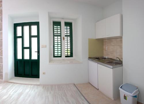 斯普利特格里克公寓的厨房设有白色的墙壁和绿色的门