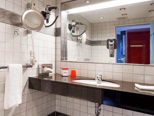 菲林根-施文宁根多尔美罗菲林根施文宁根酒店的一间带水槽和镜子的浴室