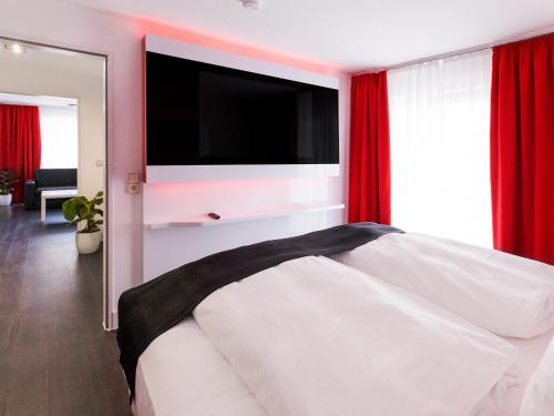 菲林根-施文宁根多尔美罗菲林根施文宁根酒店的卧室配有白色床和平面电视