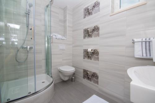 布雷拉Sea View Apartment Gin Brela的带淋浴和卫生间的白色浴室