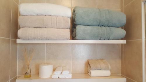 布鲁堡史特兰Mossel 11 Studio的浴室架子上的一大堆毛巾