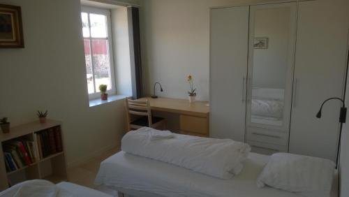 EngesvangMoselundgaard B/B og Hestehotel的一间卧室配有一张床、一张书桌和一个窗户。