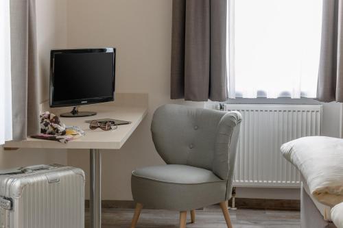 因戈尔施塔特斯里普茵民宿 的一间卧室配有一张桌子、椅子和一台电视