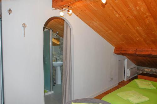 Puivert岩间磨坊旅馆的一间设有木制天花板和镜子的客房