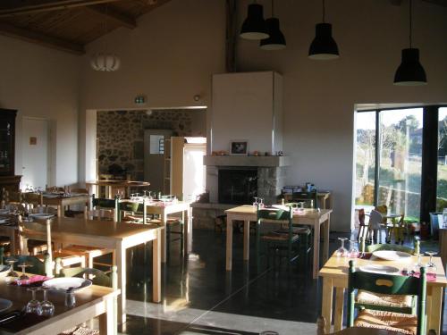 GrazacAuberge BRIASSOU的一间带桌椅和壁炉的餐厅