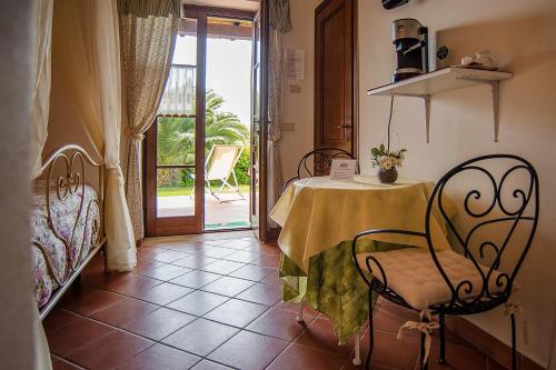 萨杜勒尼亚B&B 8380 Saturnia Terme的客房设有桌椅和阳台。