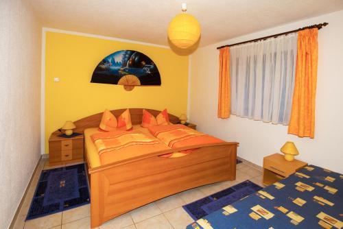 施塔特韦伦Ferienwohnung Gottlöber的一间卧室配有带橙色枕头的床