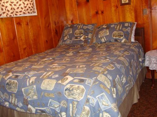 PhelpsPerch Inn Cabin的一张带蓝色被子和枕头的床