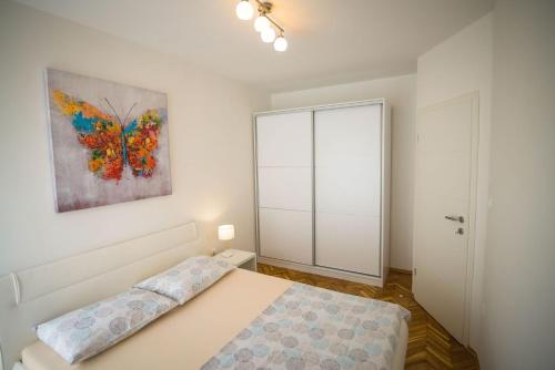 斯普利特Apartment Bebulino的卧室配有一张床,墙上挂有绘画作品