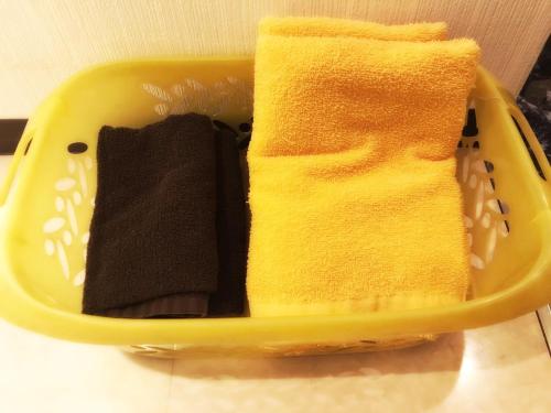 大阪马加达酒店（仅限成人）的黄色的篮子,上面有两条毛巾
