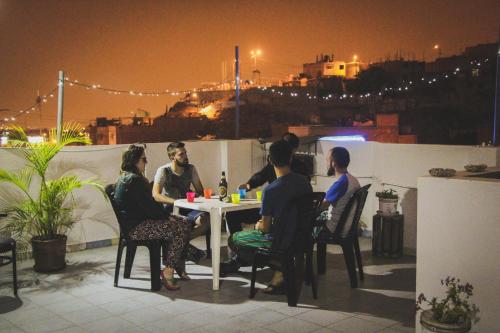 利马Tupac Lima Airport的一群人晚上坐在屋顶的桌子上