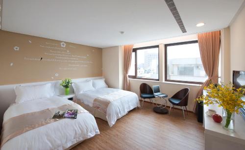 彰化市台湾大饭店 的酒店客房,配有两张床和两把椅子