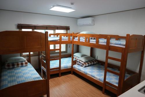 西归浦市蓝岛旅馆的一间客房内设有四张双层床的房间