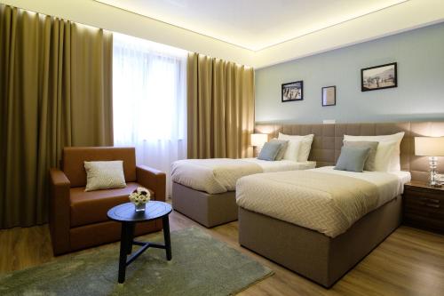 特雷比涅SL Industry Hotel的酒店客房,设有两张床和一张沙发