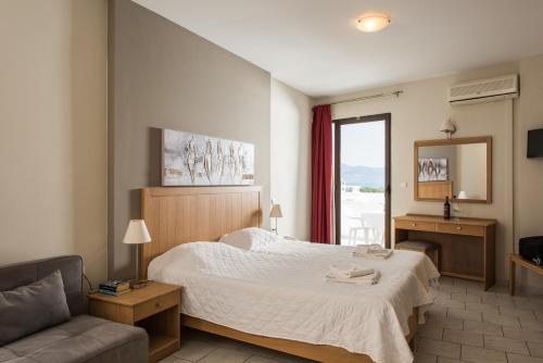 基萨莫斯米缇洛斯公寓酒店的一间卧室配有一张床、一张沙发和一个窗口