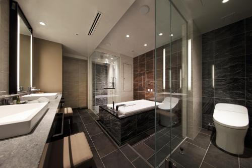 仙台仙台东大都会酒店 的一间带两个盥洗盆、淋浴和卫生间的浴室