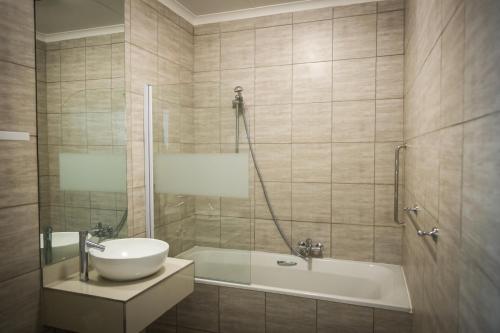 布隆方丹棕榈旅馆的浴室配有盥洗盆和浴缸。