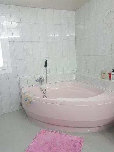 马略卡岛帕尔马Son Roqueta的白色的浴室设有浴缸和粉红色地毯。