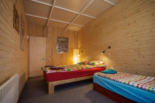 UdabnoOasis Club Cottages的木墙客房的两张床