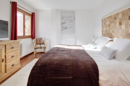 上阿兰Esquirós by FeelFree Rentals的一间卧室配有一张大床和一把椅子