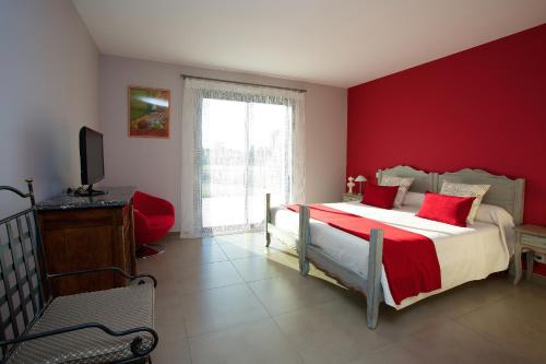 卡瓦永Aubade en Luberon的一间卧室配有一张红色墙壁的床和电视